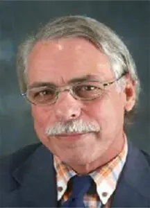 A man with glasses and a mustache wearing a suit.