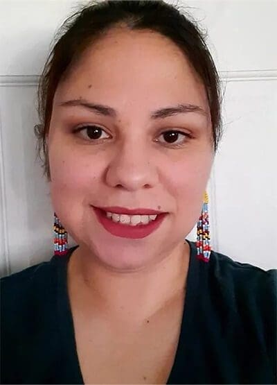 A woman with red lipstick and long earrings.