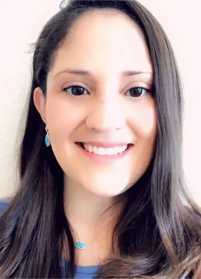 A woman with long hair smiles for the camera.