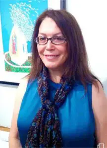 A woman wearing glasses and a blue top.