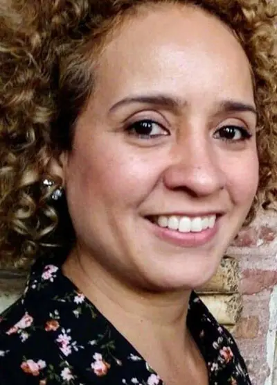 A woman with curly hair and a black shirt.