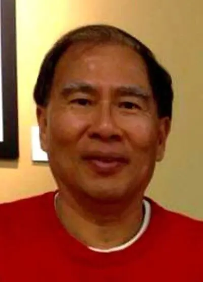 A man in red shirt smiling for the camera.