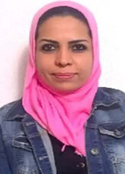 A woman with pink head scarf and denim jacket.