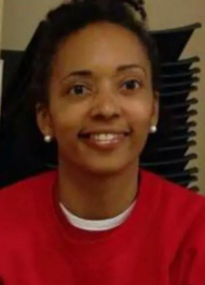 A woman in red shirt smiling for the camera.