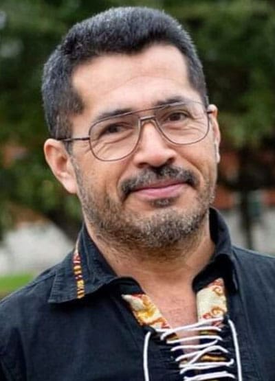 A man with glasses and beard wearing a black shirt.