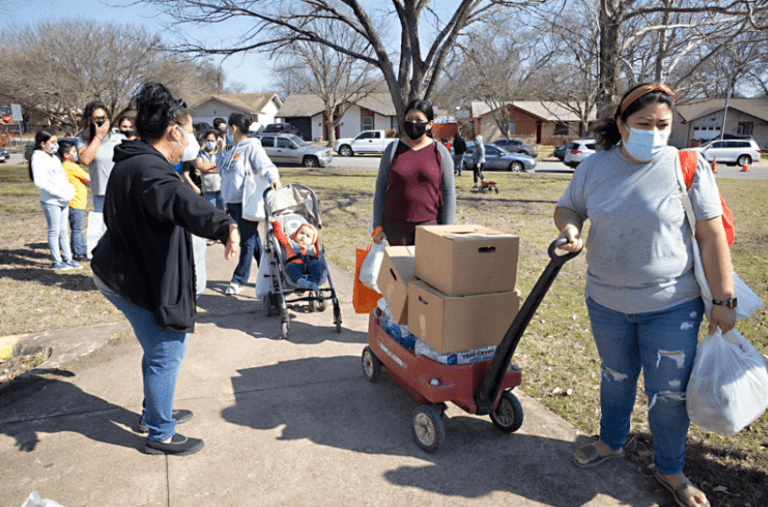 A group of people standing around with boxes.